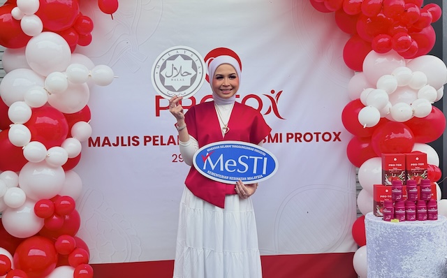 Cikgu Ayu bersama logo MeSTI dan Halal Malaysia di pelancaran Protox Mix Berries